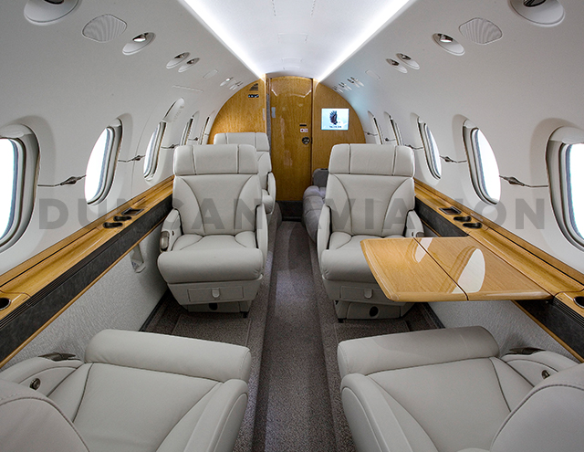 Hawker 800 interior in warm gray and honey-toned wood