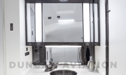 Interior refurbishment of lavatory with white counter and dark wood cabinet