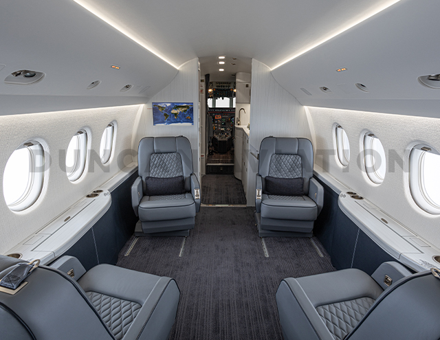 Interior refurbishment of Falcon 2000 with blue-gray club seats looking to front of the plane