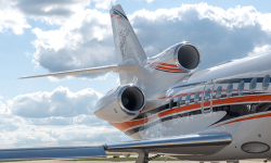 Photo of rear tail and engines on a Falcon 900 with newly painted exterior in white with dynamic orange and navy stripes