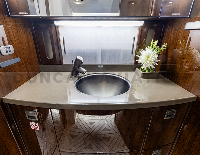 Lav sink in refurbished Falcon 2000 with dark wood and light counters
