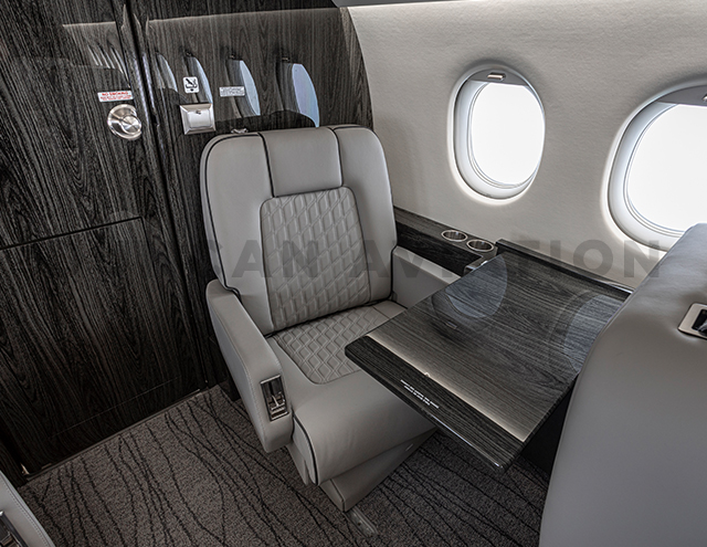 Alternate angle of club seat and conference table in refurbished Falcon 2000