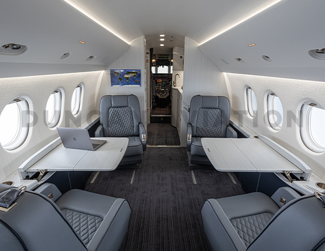 Blue-gray club seats with white conference tables-Falcon 2000 interior refurbishment