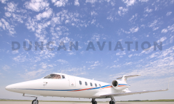 Sleek Learjet 60 exterior with new white paint and blue and red accent stripes