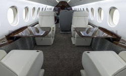 White leather seats with dark wood tables in Falcon 900