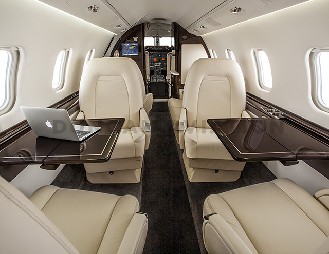 Interior of updated Learjet 60 with cream upholstery and dark wood