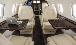 Interior of updated Learjet 60 with cream upholstery and dark wood