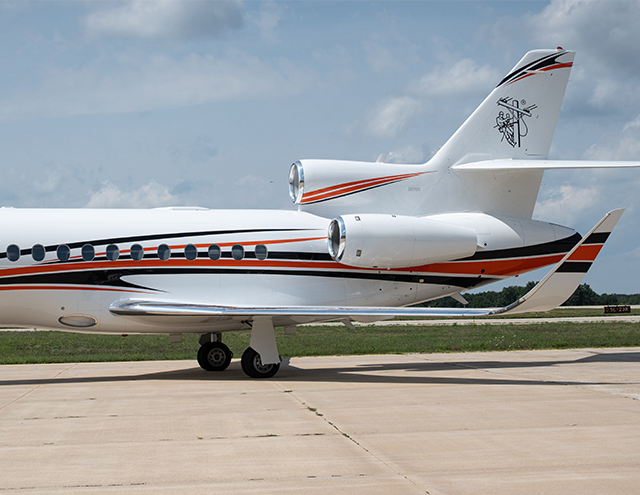 Tail and engines of Falcon 900 painted by Duncan Aviation with orange and navy stripes on white
