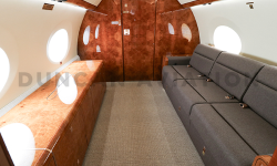 Interior of Gulfstream 650 with cool brown divan couch by Duncan Aviation