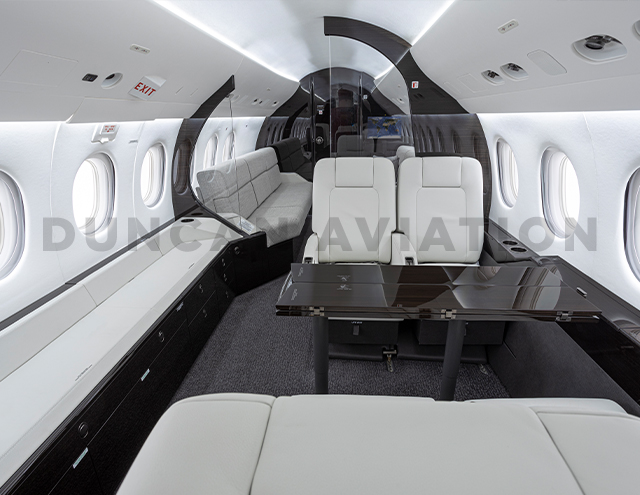 White leather upholstered club seats and dark wood conference table in modern refurbishment of Falcon 2000