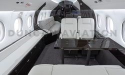 White leather upholstered club seats and dark wood conference table in modern refurbishment of Falcon 2000