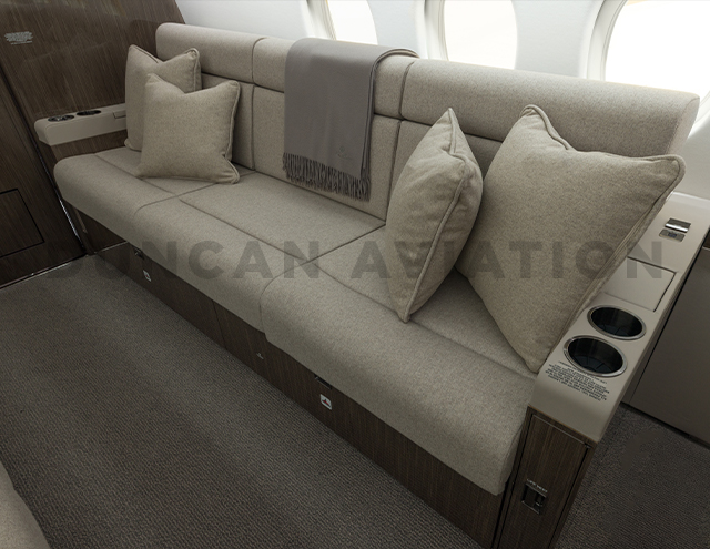 Divan to seat three in cool beige leather with matching pillows on refurbished Falcon 900