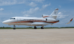 Exterior of Falcon 900 in white with blue and orange strip painted by Duncan Aviation