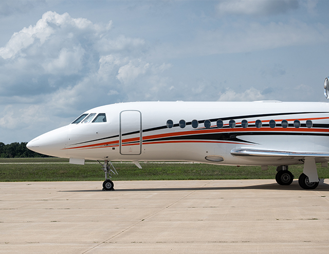 Falcon 900 painted in white with dynamic orange and navy stripe