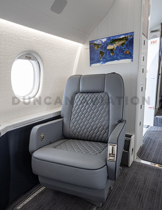 Comfy club seat in soft gray in Falcon 2000 interior refurbishment