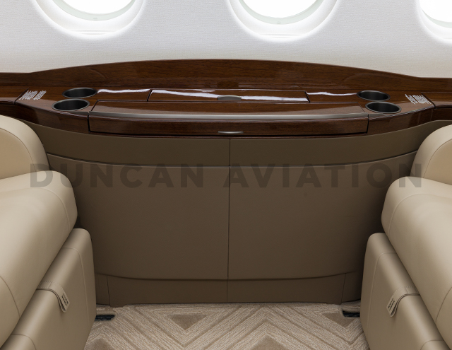 Close up of drink rail with dark wood tones in newly refurbished Falcon 2000 by Duncan Aviation
